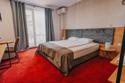 a bedroom with a large bed and a red carpet at Villa Rosa in Timişoara