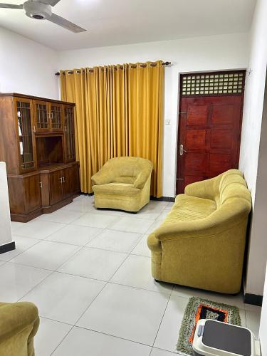 a living room with two chairs and a door at Himo Guest Inn in Dehiwala