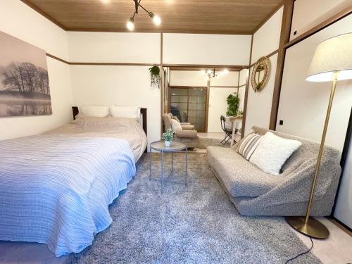 a bedroom with a bed and a couch at Best Shinjuku Modern Full-furnished Family size Apartment5 ONLY 2min to Shinjuku by Train in Tokyo