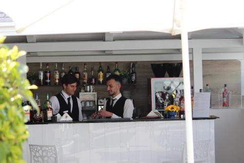 two men are standing behind a bar in a restaurant at Palazzo Firenze in Naples