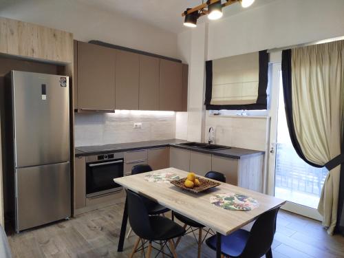 a kitchen with a table with chairs and a refrigerator at Simple and Relaxing House! in Kalamata