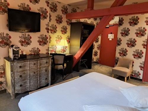 a bedroom with a bed and a desk and a television at Hôtel de Paris in Besançon