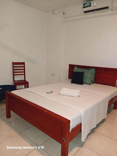 a large bed in a room with a chair at The Lovina Place in Mount Lavinia