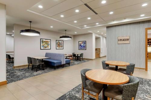 a waiting area with tables and chairs in a lobby at Hyatt Place St. Louis/Chesterfield in Chesterfield