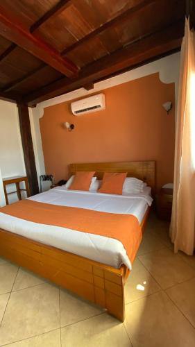a bedroom with a large bed with orange sheets at Hotel Don Pedro De Heredia in Cartagena de Indias