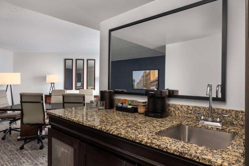 a bathroom with a sink and a large mirror at Embassy Suites Birmingham in Birmingham