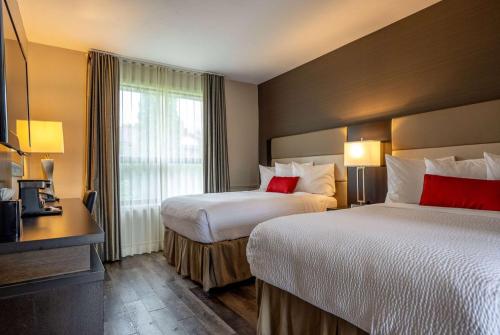 a hotel room with two beds and a window at Ramada by Wyndham Ottawa On The Rideau in Ottawa