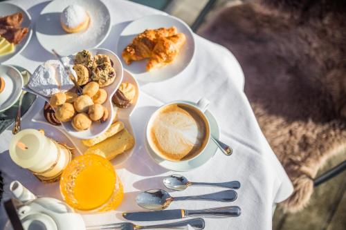 a table topped with plates of food and a cup of coffee at Hotel Villa Stefania in San Candido