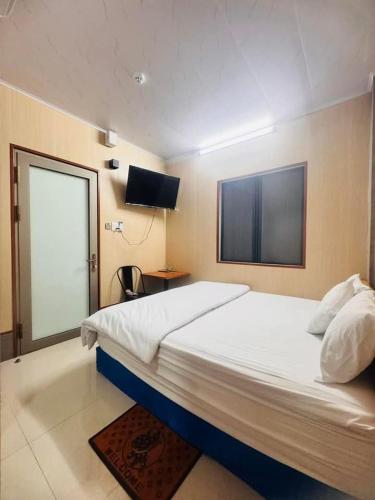 a bedroom with a large bed and a television at Vinh Hotel in Thốt Nốt