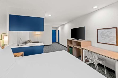a hotel room with a large bed and a kitchen at Spark by Hilton Sterling Dulles Airport in Sterling