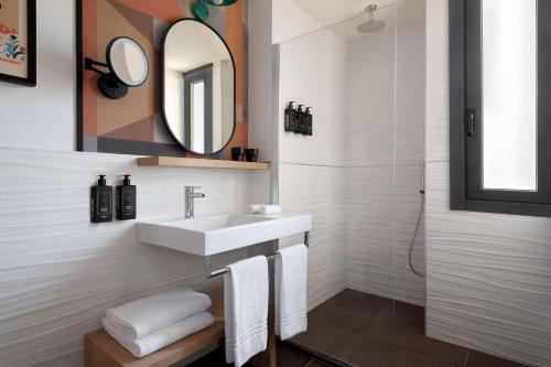 a bathroom with a sink and a mirror at The Spring House Hotel Rome Vatican, Tapestry Collection Hilton in Rome