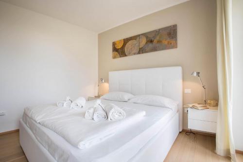 a white bed with white towels on top of it at Residence La Villa Diamante in Tignale