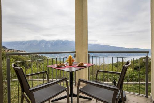 a table and two chairs on a balcony with a view at Residence La Villa Diamante in Tignale