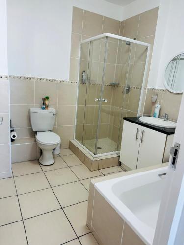 a bathroom with a toilet and a shower and a sink at Sea- Esta in Densainagar