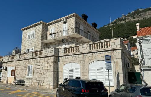 a building with two cars parked in front of it at Studio Rimac in Dubrovnik