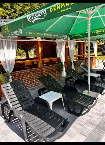 a group of chairs and umbrellas on a patio at Jerry's Forest in Banja Luka