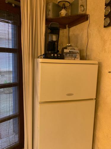 - un réfrigérateur blanc dans une cuisine à côté d'une fenêtre dans l'établissement Apartment Maison La Roche, à Peyriac-de-Mer