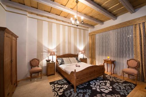 a bedroom with a bed and two chairs at Chateau GrandCastle in Liptovský Hrádok
