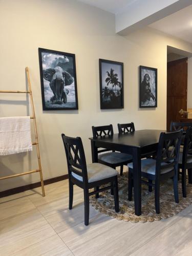 a dining room with a black table and chairs at Unit One by Hideout Lounge in Kandy