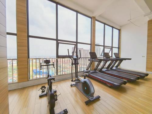 a gym with several tread machines and large windows at Amanda Hotel堆谷里酒店 in Phnom Penh