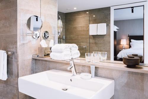 a bathroom with a sink and a large mirror at Pillows City Hotel Brussels Centre in Brussels