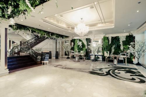 a large room with a chandelier and a staircase at Tower Club at lebua in Bangkok