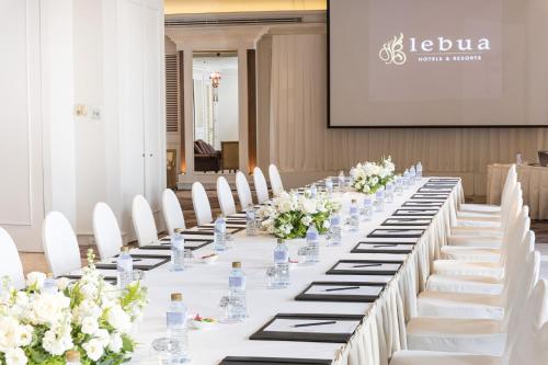 a long table with white chairs and flowers at lebua at State Tower in Bangkok