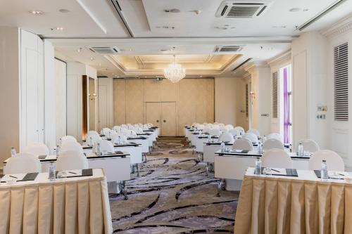 a room with rows of tables and white chairs at lebua at State Tower in Bangkok