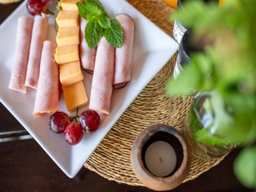 a plate of food with meats and fruit on a table at eKhaya Bush Lodge in Hoedspruit