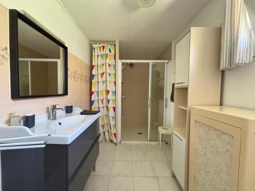 a bathroom with a sink and a shower at Maison de campagne lumineuse spacieuse dans impasse au calme a proximité d'un chateau deux vérandas grand jardin cabane pour vélos, pres Port en Bessin et Bayeux, proche plages du débarquement in Commes