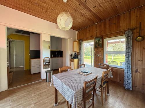 une cuisine et une salle à manger avec une table et des chaises dans l'établissement Maison de campagne lumineuse spacieuse dans impasse au calme a proximité d'un chateau deux vérandas grand jardin cabane pour vélos, pres Port en Bessin et Bayeux, proche plages du débarquement, à Commes