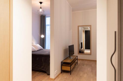 タルトゥにあるCozy Riia kvartal apartment with free parking and air conditioningのベッドルーム(ベッド1台、鏡付)