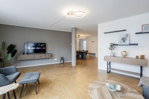 a living room with a couch and a tv on a wall at GT-City Suite 03 I Balkon I Gas-Grill I Smart TV in Gütersloh