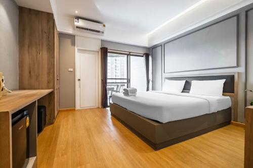 a hotel room with a bed and a desk at Boss Mansion in Bangkok