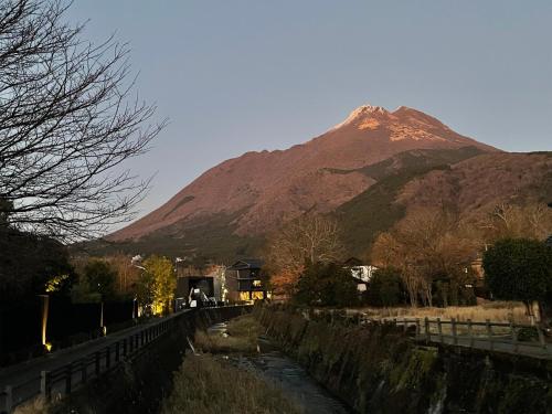 a mountain in the distance with a river in front of it at Yufuin Onsen Ryokan Hananomai in Yufuin