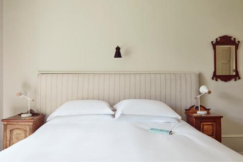 a bedroom with a white bed with two lamps at Boath House Hotel in Nairn