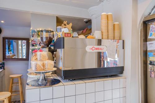 a restaurant with a counter with a microwave and some food at Boss Mansion in Bangkok