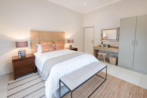 a bedroom with a large bed and a desk at eKhaya Bush Lodge in Hoedspruit