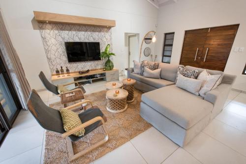 a living room with a couch and a tv at eKhaya Bush Lodge in Hoedspruit