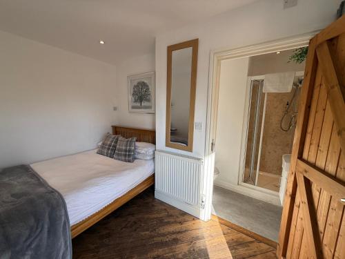 a bedroom with a bed and a large window at The Stables - Deer Park Farm in Solihull