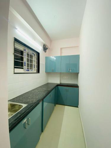 a kitchen with blue cabinets and a sink at Freedom Flats-Extended stay in Kondapur