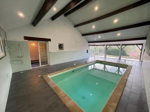 une grande chambre avec une piscine dans une maison dans l'établissement Villa 21 couchages avec piscine interieure chauffée, à Belleu