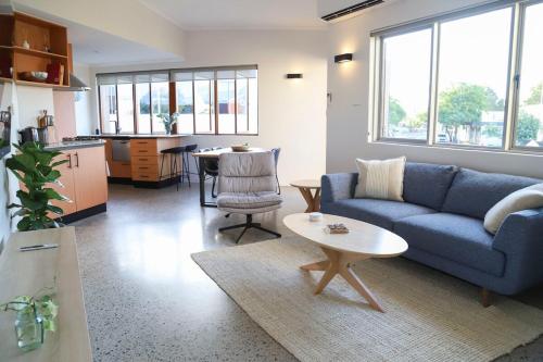 a living room with a blue couch and a table at Ellen City Centre in Fremantle