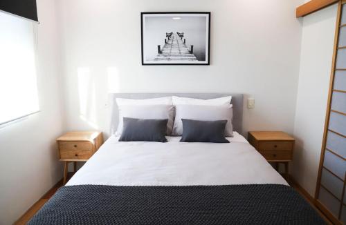 a bedroom with a large white bed with two night stands at Ellen City Centre in Fremantle