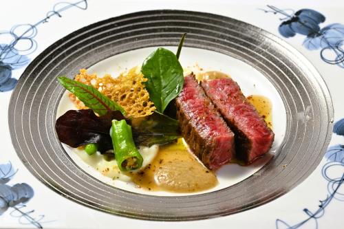a plate of food with meat and vegetables on it at Hana No Shizuku in Ureshino