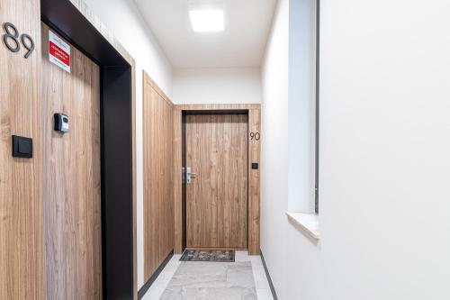 a hallway with a wooden door in a building at SuperApart Habicha 19 in Warsaw
