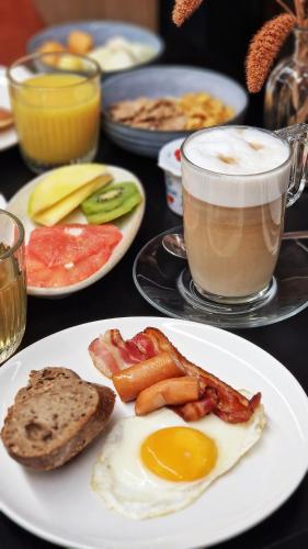 a table with plates of breakfast food and a cup of coffee at Afterwork Hotel in Etoy