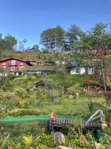 a garden with a bench and houses in the background at Huha's Farmstay Đà Lạt in Lạc Dương
