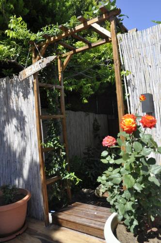 a wooden arbor with a ladder and flowers in a garden at Sunside Inn Hotel in Kérynia
