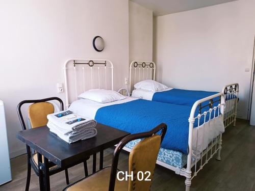 a bedroom with two twin beds and a table at HOTEL LE FONTENOY in Provins